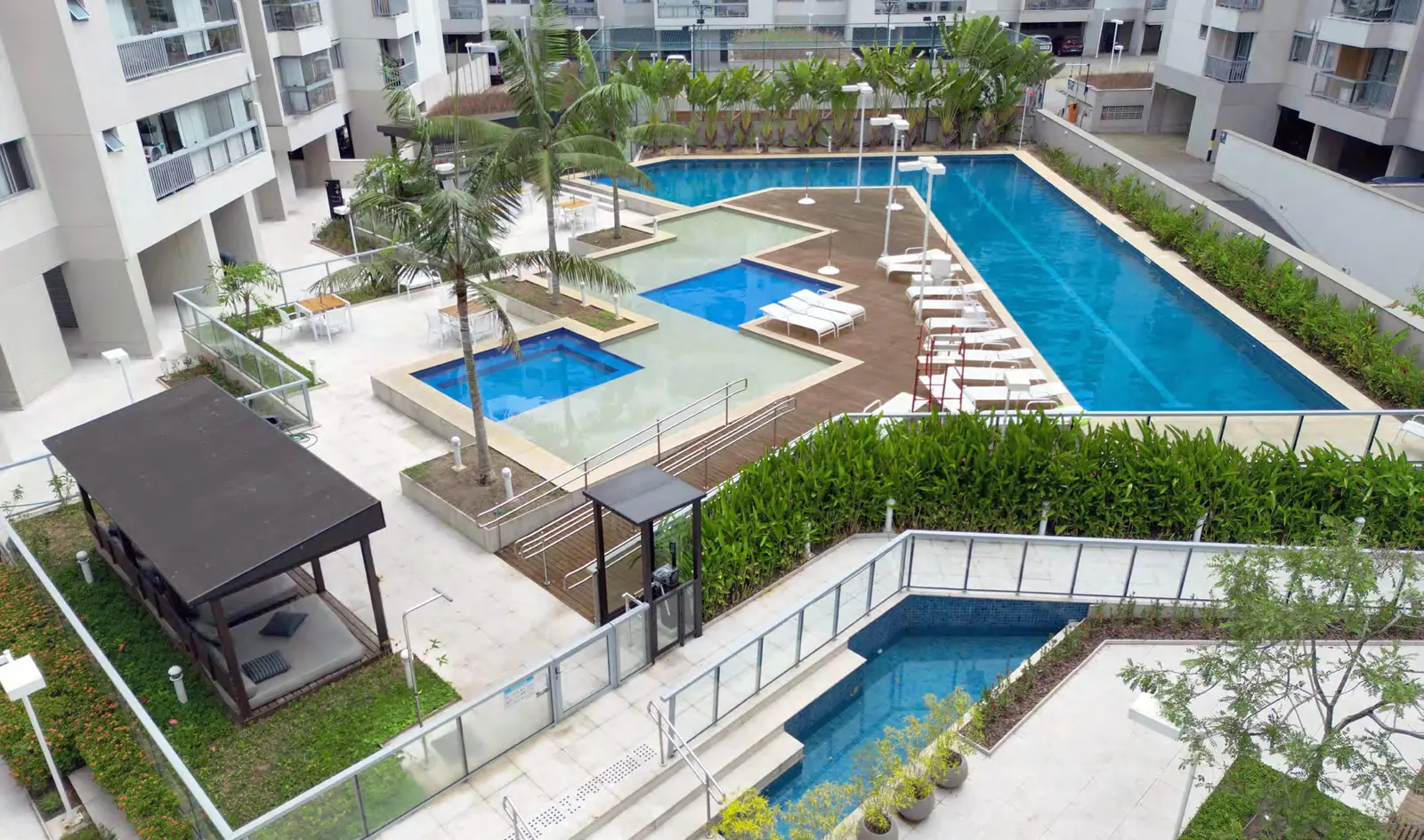 Imagem real da área de lazer do RG Personal Residences com piscinas